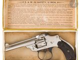 un gros plan d'un revolver dans une boîte, sur fond blanc