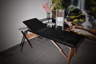 une table de massage dans une pièce avec une cascade en arrière-plan