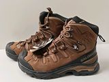 des chaussures de randonnée marron posées sur une surface blanche, sur fond blanc