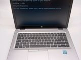 a laptop with a blue screen sitting on a white table