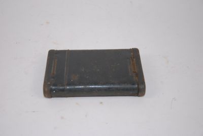 un petit portefeuille noir posé sur une table blanche