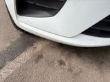 a close up of a car ' s front bumper on the street