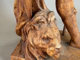 statue of a man with a lion on a wooden base