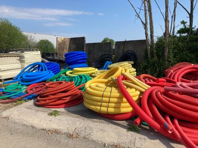 de nombreux tuyaux de différentes couleurs posés par terre les uns à côté des autres