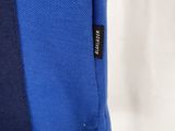 the back of a blue and black shirt with a black label on it