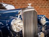 a close up of a blue car with a bird on the front