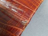 crocodile skin leather case for a cell phone on a gray surface