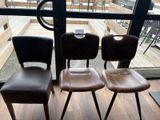 trois chaises placées côte à côte devant une fenêtre