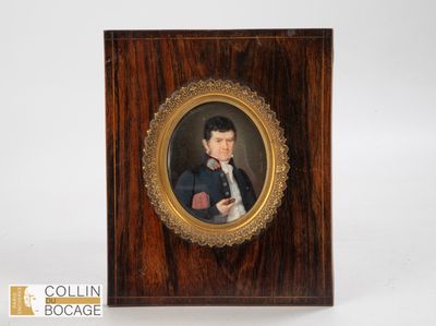 portrait d'un jeune homme en costume et nœud papillon, dans un cadre en bois