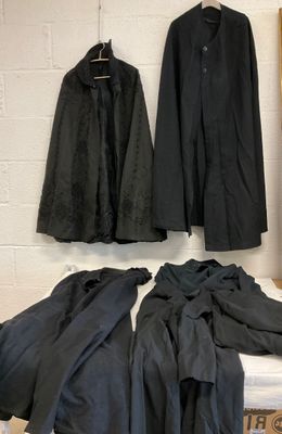 two coats hanging on the wall next to a bed