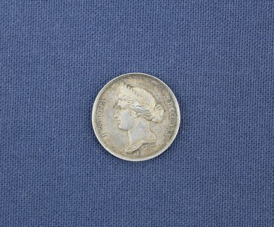 un gros plan d'une pièce de monnaie posée sur un tissu bleu