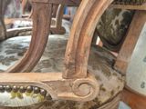 a close up of a wooden chair with a white and brown upholstered seat