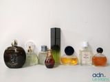 several different types of perfume bottles lined up on a white surface
