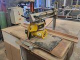 une photo d'une machine en train de scier un morceau de bois