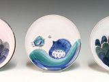 three oval shaped plates with blue and white designs on them