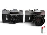 two old cameras sitting side by side on a white surface