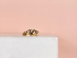 un gros plan d'une bague en or posée sur un bloc de marbre