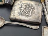 a silver box with a silver spoon and spoon rest on a table