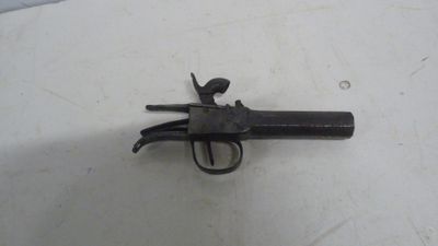 gros plan d'un pistolet sur une table à fond blanc