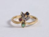 a close up of a gold ring with two different colored stones