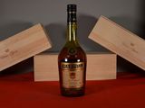 une bouteille de whisky posée sur une table à côté d'une caisse en bois