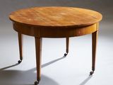 La table est en bois et ses pieds sont équipés de roulettes.