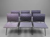quatre chaises aux assises tressées, alignées sur une surface grise
