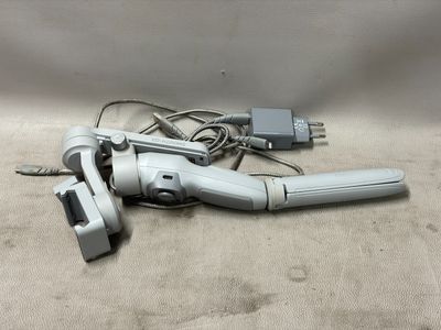 un sèche-cheveux argenté et noir et un chargeur posés sur une table