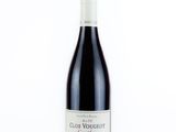 une bouteille de vin rouge posée sur une surface blanche