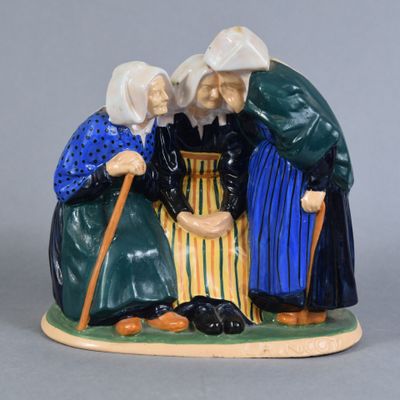 deux figurines représentant des vieilles femmes assises sur un banc