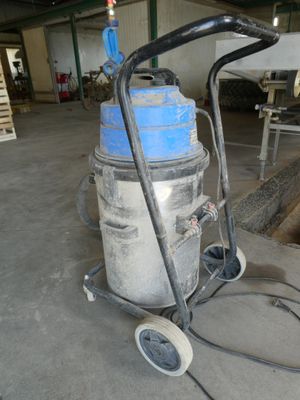 un aspirateur bleu et blanc posé sur un chariot dans un entrepôt