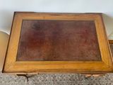 a small wooden table with a glass top on the floor