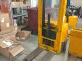 a forklift in a warehouse with boxes and boxes