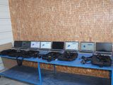 many laptops on a blue table in front of a brick wall