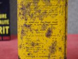 un vieux bidon jaune avec une étiquette noire, posé à côté d'un livre