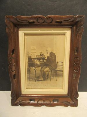 une vieille photo représentant un homme assis à une table en train de jouer du piano