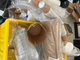 un bac jaune rempli de gobelets en plastique et d'autres objets