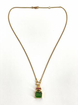 un collier en or avec un pendentif en pierre verte et une chaîne en or