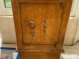 a small wooden cabinet sitting on the floor in front of a window