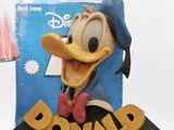 mickey mouse figurine on display in front of a lamp