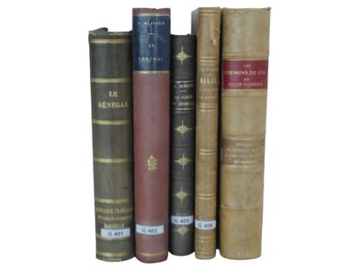 several old books are stacked on top of each other on a white surface