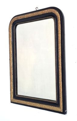 un miroir noir et doré accroché au mur