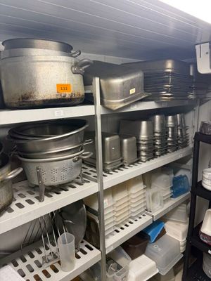 de nombreuses casseroles et poêles sur les étagères de la cuisine