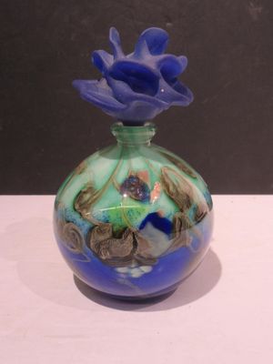 un vase en verre surmonté d'une fleur bleue