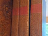 three books that are sitting on a shelf in a room