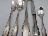 a lot of silver spoons and forks on the table