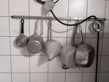 pots and pans hanging on a wall in a kitchen