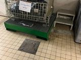 un panier en métal sur lequel est accrochée une pancarte, dans une pièce