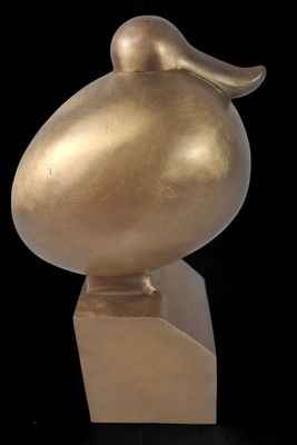 sculpture of a golden bird on a pedestal against a black background