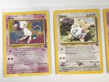 four pokemon cards are on a white surface with a yellow border